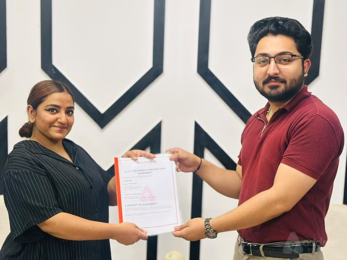 Client handing over signed plot purchase and construction agreement